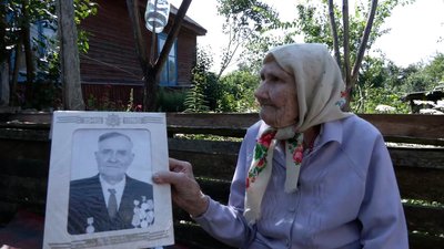 Ювілярка Олена з Чернігівщини тримає в руках портрет свого чоловіка Ювілярка Олена з Чернігівщини тримає в руках портрет свого чоловіка