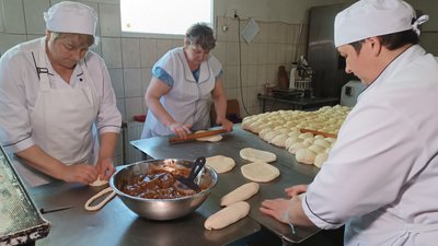 Пекарі розкатують тісто для пирогів та рулетів Пекарі розкатують тісто для пирогів та рулетів