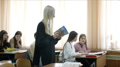 Старшокласниця читає з зошита на уроці Старшокласниця читає з зошита на уроці