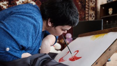 Оксана Попадюк тримає пензлик зубами, так вона малює картини Оксана Попадюк тримає пензлик зубами, так вона малює картини