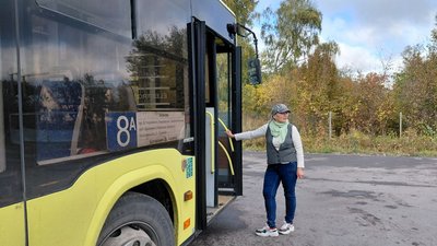 Жінка-водійка біля автобуса
