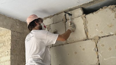 Волонтер демонтує пошкоджену будівлю старостату Волонтер демонтує пошкоджену будівлю старостату