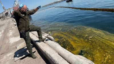 Екоінспектор бере воду для аналізу в порту Чорноморська