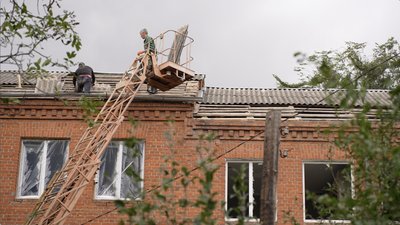 Фахівці кладуть дах на пошкоджений будинок