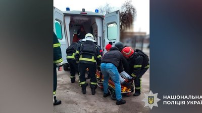 Правоохоронці евакуйовують жінку з пораненнями до медзакладу