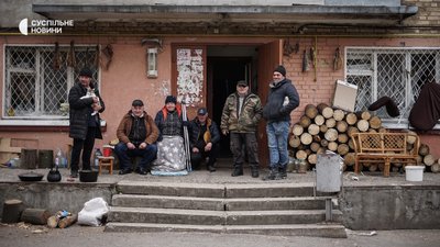 Жителі одного з будинків у Бучі, які разом пережили російську окупацію, біля під'їзду свого дому, квітень 2022 року.