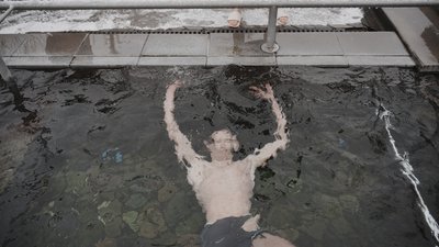 Чоловік купається у освяченій воді під час свята Водохрещі у Харкові в Саржиному Яру