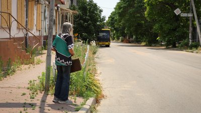 Жінка очікує автобус в центрі Херсона