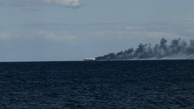 Дим над цивільним судном, що горить після російського обстрілу у морі біля Одеси