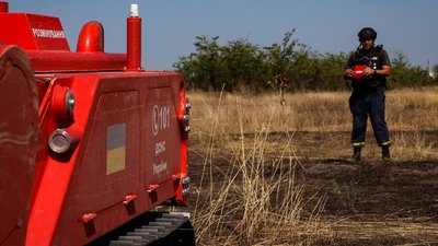 Сапер поруч з машиною для механічного розмінування Сапер поруч з машиною для механічного розмінування