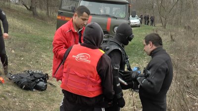 Водолазу допомагають вдягати спеціальне спорядження Водолазу допомагають вдягати спеціальне спорядження