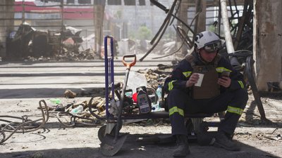 Рятувальник перепочиває під час розбору завалів у знищеному авіабомбами "Епіцентрі"