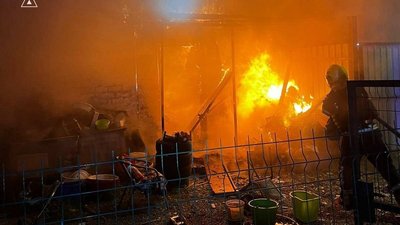 Рятувальник гасить пожежу, яка виникла внаслідок обстрілу РФ по Києву