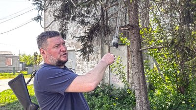 Начальник Святогірської МВА Володимир Рибалкін показує оптоволокно від російського дрона