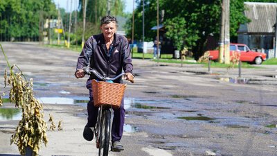 Чоловік їде на велосипеді на Харківщині