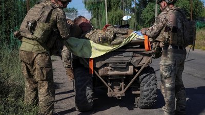 Українські військовослужбовці готуються евакуювати пораненого побратима на лінії фронту
