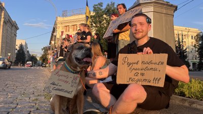 Чоловік та собака з картонками на акції протесту в Харкові