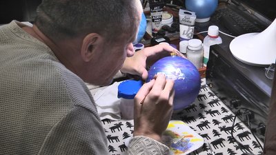 На Волині художник-переселенець розмальовує новорічні іграшки, щоб допомогти ЗСУ