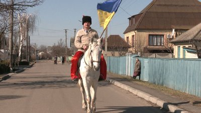 У національному строї та з прапором: козак з Черкас їздить містом на коні