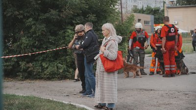 люди на місці влучання в Індустріальному районі Харкова