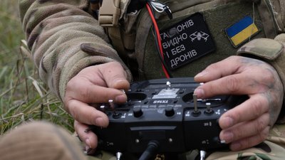 Оператор дрона тримає в руках джойстик
