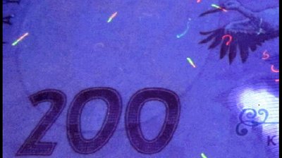 Підроблена банкнота в ультрафіолетових променях