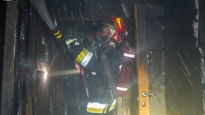 Рятувальник гасить пожежу в будинку на вулиці Варшавській
