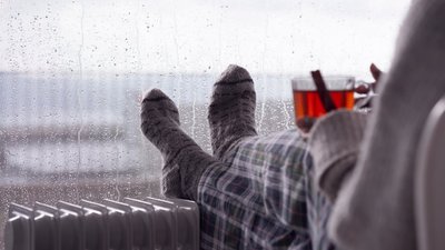 Людина п'є чай перед вікном