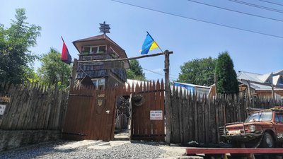 Над ворітьми – жовто-блакитний та червоно-чорний прапори. Над ворітьми – жовто-блакитний та червоно-чорний прапори.