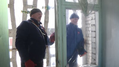 Містяни закривають вибите скло в вікнах поліетиленовою плівкою. 27.02.2023 рік.
