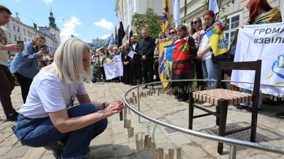 Мати зниклого безвісти військового чіпляє жетон з іменем сина