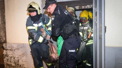 Рятувальники виносять жінку з пожежі