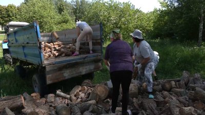 Жінки вантажать дрова у прикордонному селі на Чернігівщині, травень 2024