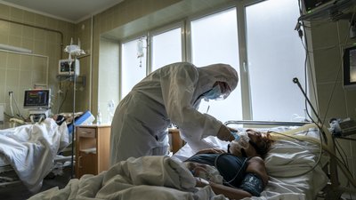 Медсестра у захисному костюмі перевіряє стан пацієнтки з COVID-19 у відділенні невідкладної допомоги. Львів, січень 2021 року