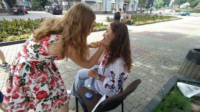 Учасниця ярмарку наносить аквагрим Учасниця ярмарку наносить аквагрим