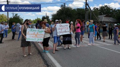 На дорозі у селищі Пантаївка люди ходять пішохідним переходом. В руках у них плакати. На дорозі у селищі Пантаївка люди ходять пішохідним переходом. В руках у них плакати.