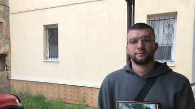 Чоловік тримає портрет загиблих у ДТП друзів Чоловік тримає портрет загиблих у ДТП друзів