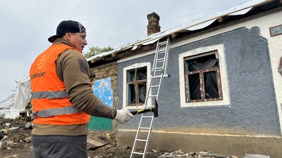 Волонтер Юрій Осіпов поруч з будинком