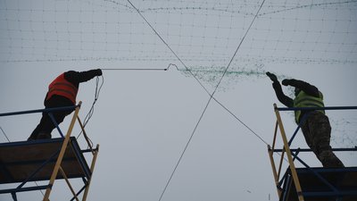 Комунальники натягують антидронову сітку