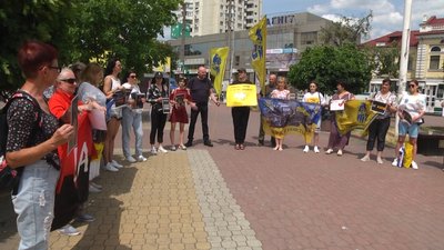 Учасники акції тримають в руках плакати Учасники акції тримають в руках плакати