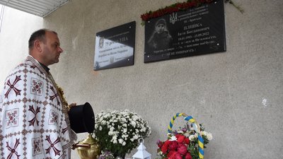 Отець Юрій Матвіїшин освячує дошку