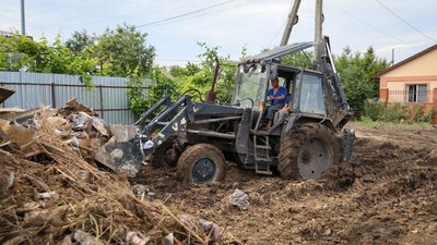 Сусід Олени Романюк допомагає жінці вивезти залишки будівлі на сміттєзвалище Сусід Олени Романюк допомагає жінці вивезти залишки будівлі на сміттєзвалище