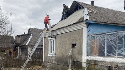 Місцеві жителі допомагають відновити покриття будинку після атаки, 1 лютого, 2025