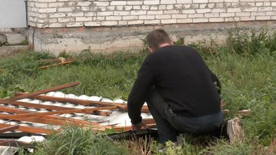 Петро Рудь збирає розкидану бляху з покрівлі своєї майстерні Петро Рудь збирає розкидану бляху з покрівлі своєї майстерні