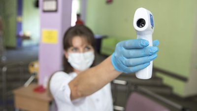 Медик тримає у руці безконтактний цифровий тонометр