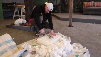Один з волонтерів розбиває парафін для того, щоб потім його розтопити на вогні Один з волонтерів розбиває парафін для того, щоб потім його розтопити на вогні