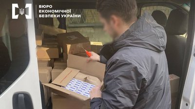 Правоохоронець оглядає ящики із цигарками