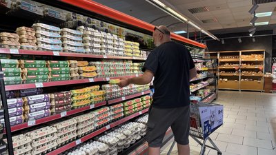 Чоловік купує харчі в супермаркеті