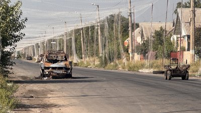 Знищена техніка стоїть на дорозі, накрита антидроновою сіткою, Донеччина