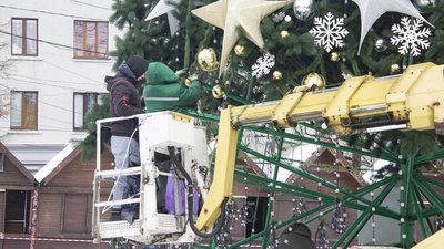 Працівники знімають іграшки з ялинки Працівники знімають іграшки з ялинки